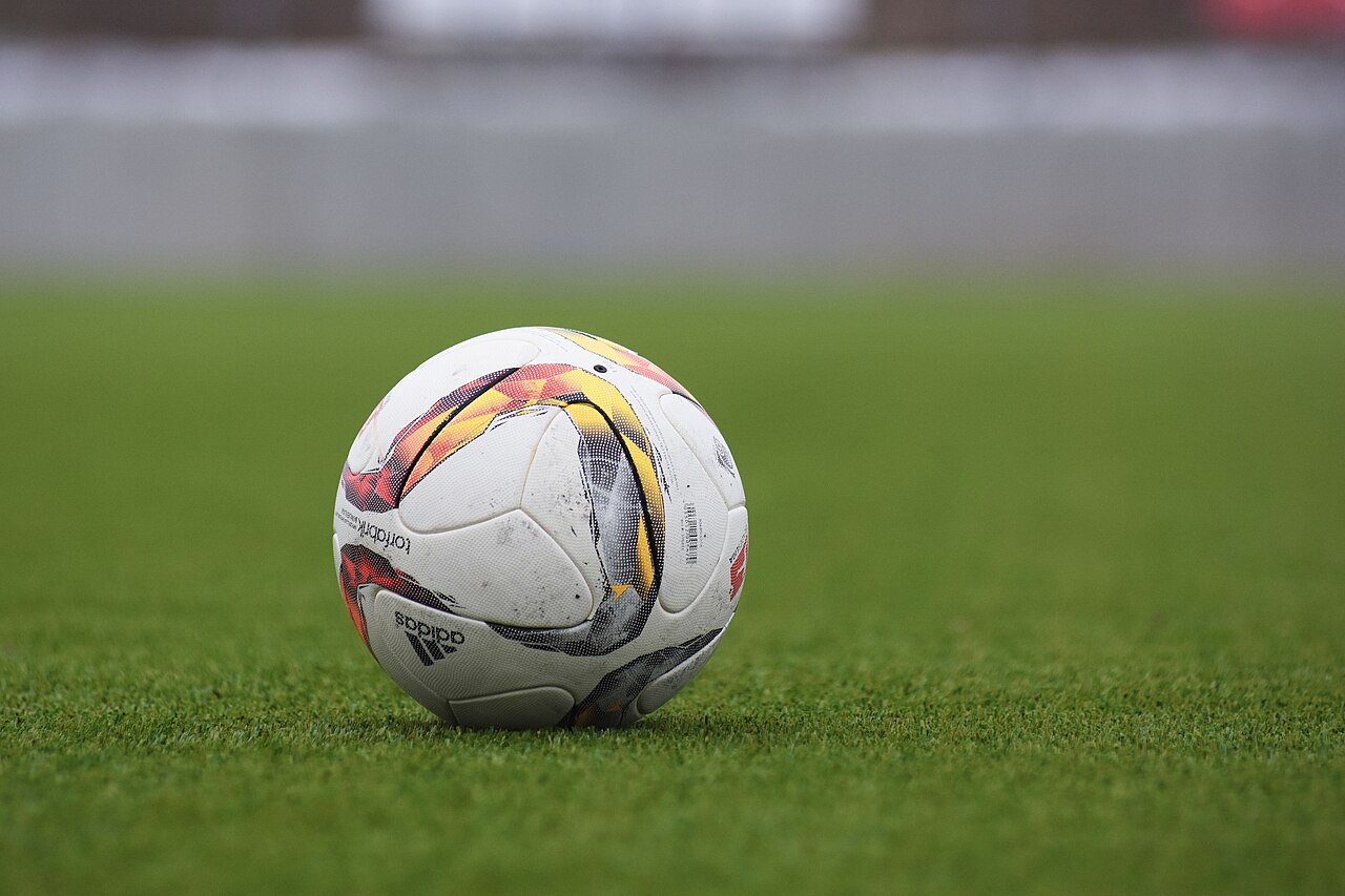 A football resting on a grass pitch.